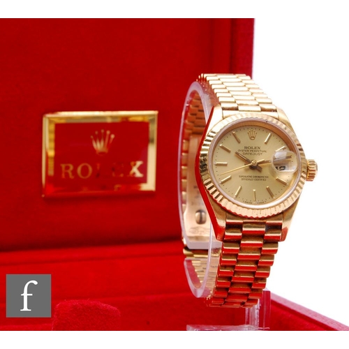 A lady's 18ct Rolex Datejust gilt baton and date facility to a circular champagne dial, case diameter 26mm, to a Rolex 18ct bracelet, total weight 79.5g, ref 69178, complete with box and papers.