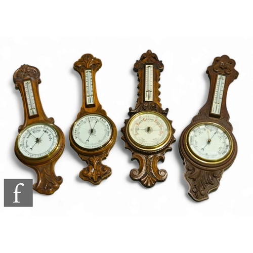 277 - Four various carved oak circular aneroid barometers, each incorporating thermometers, height 88cm, d... 