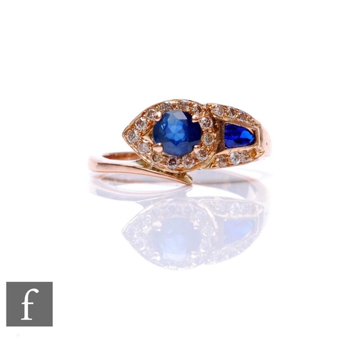 68 - An 18ct sapphire and diamond stylised snake ring with two shaped sapphires set within diamond border... 