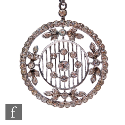 74 - An early 20th Century silver paste set open work pendant of pierced circular form suspended from a s... 