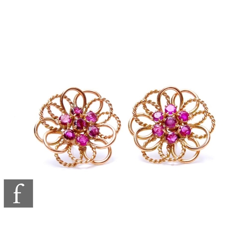 84 - A pair of 9ct circular stud earrings, each with a central cluster of seven rubies to wirework border... 