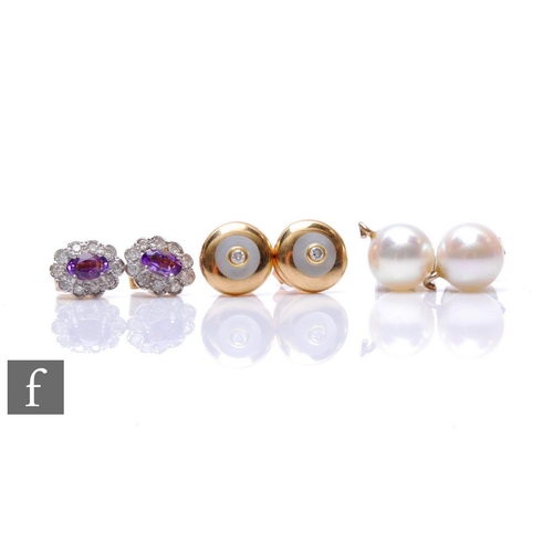 92 - Two pairs of 9ct stud earrings to include a mother of pearl set with a diamond example and an amethy... 