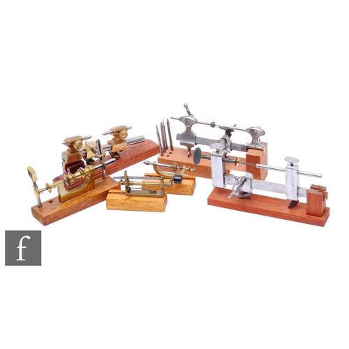 311 - Six early 20th Century watch maker's lathes and tools, each on a mahogany plinth base. (6)