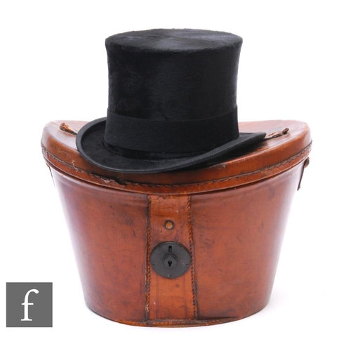 324 - A Victorian black felt top hat by Christy's London, size 6 3/4, with brown leather hat box.