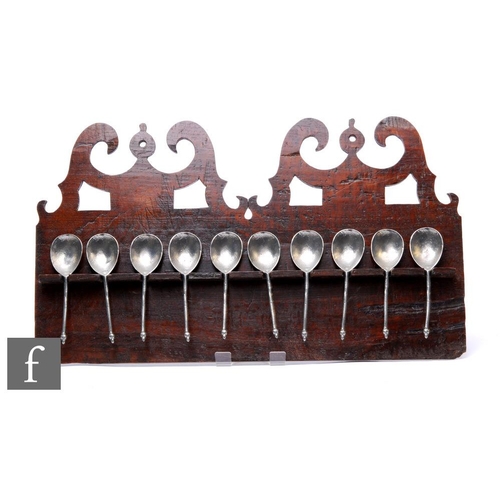 327 - An 18th Century oak Welsh spoon rack, pierced pediment over a board back and rail, with ten pewter a... 