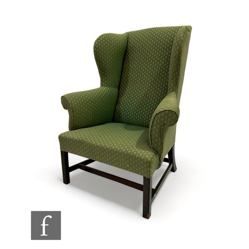 476 - A George I style wing arm chair on square mahogany block legs united by rail stretchers, upholstered... 