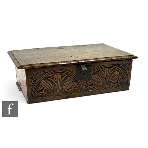 483 - An 18th Century carved oak bible box, the edge hinged lid over a carved floral lunette front, width ... 