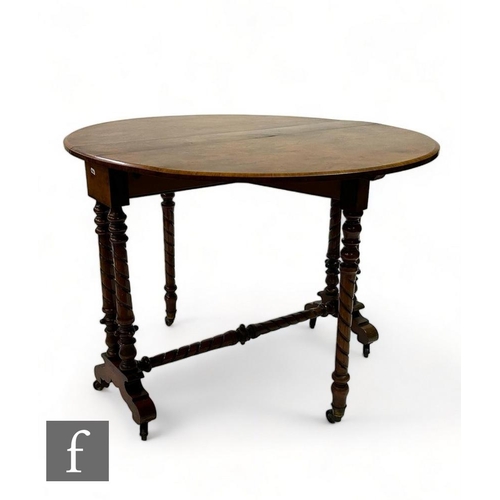 498 - A Victorian figured walnut oval drop flap Sutherland dining table on ring turned supports united by ... 