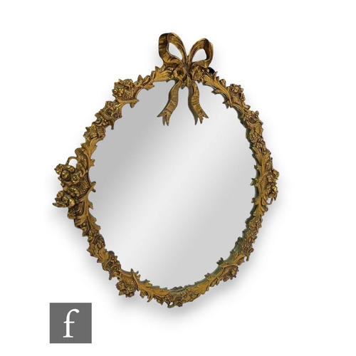 509 - A 20th Century gilt dressing table mirror, the oval plate bordered with fruit and boughs, surmounted... 