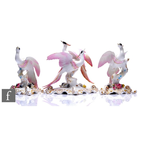 843A - A collection of Royal Crown Derby exotic bird figures, each modelled as birds perched on rockwork en... 