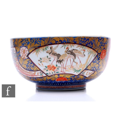 890 - An early 20th Century Japanese Imari punch bowl, the large bowl decorated with red and blue enamels,... 