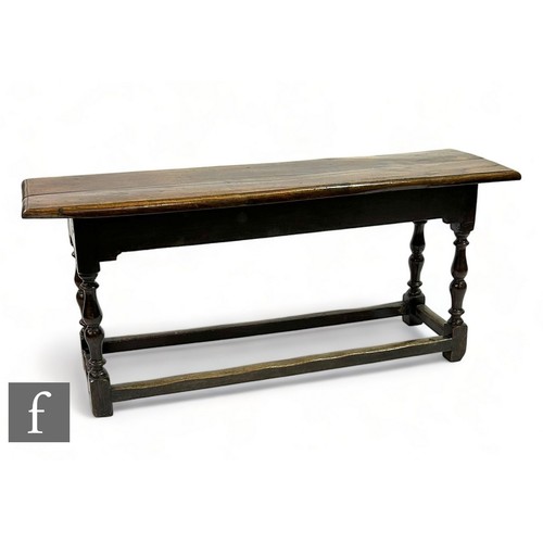 469 - A 17th Century style oak plank top bench on turned splayed legs united by rail stretchers, height 52... 