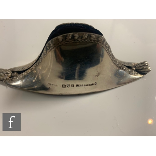 197 - A hallmarked silver pin cushion modelled as a Napoleon hat with acorn and leaf detail to borders, le... 