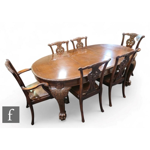 454 - An Edwardian Chippendale style oval extending mahogany dining table, the floral carved edge over a p... 