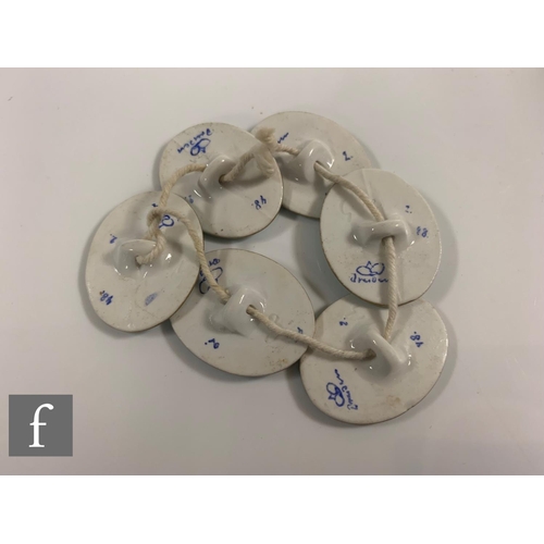 305 - A set of five enamelled decanter labels with a set of six transfer printed buttons and a cased silve... 