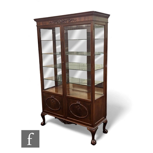 455 - An Edwardian mahogany display cabinet of large proportions, the adjustable shelves enclosed by a pai... 