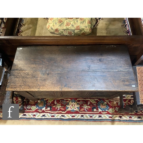 492 - An 18th Century carved oak coffer, the plank top over a triple panel leaf and lunette decorated fron... 