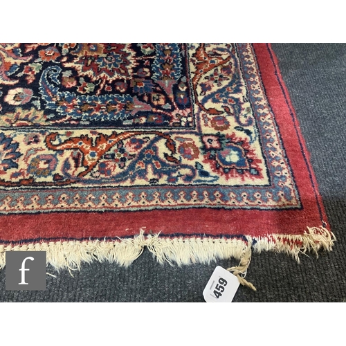 459 - A Heriz style carpet, all over floral and fruit design on a red ground within a multi running floral... 