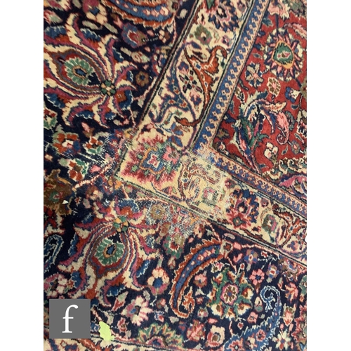 459 - A Heriz style carpet, all over floral and fruit design on a red ground within a multi running floral... 