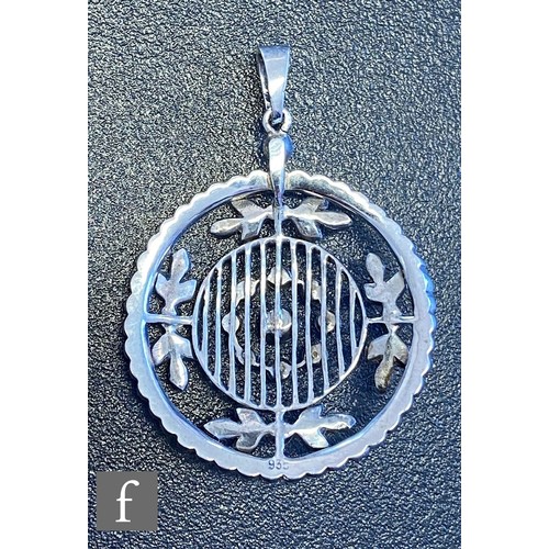 74 - An early 20th Century silver paste set open work pendant of pierced circular form suspended from a s... 