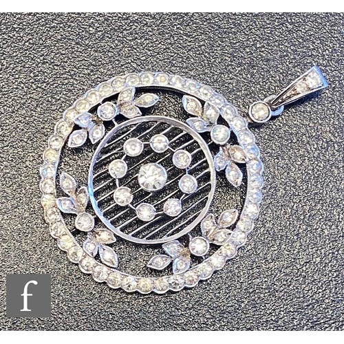 74 - An early 20th Century silver paste set open work pendant of pierced circular form suspended from a s... 