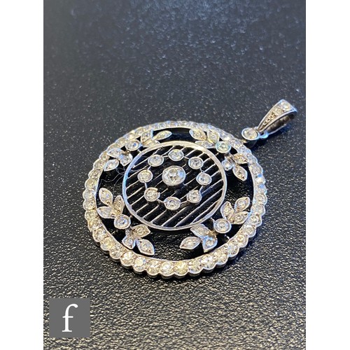 74 - An early 20th Century silver paste set open work pendant of pierced circular form suspended from a s... 