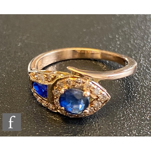 68 - An 18ct sapphire and diamond stylised snake ring with two shaped sapphires set within diamond border... 