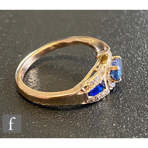 68 - An 18ct sapphire and diamond stylised snake ring with two shaped sapphires set within diamond border... 