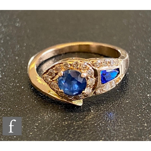 68 - An 18ct sapphire and diamond stylised snake ring with two shaped sapphires set within diamond border... 