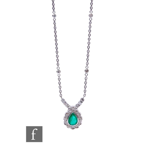 95 - An 18ct white gold emerald and diamond pendant, tear shaped emerald within a border of twelve brilli... 