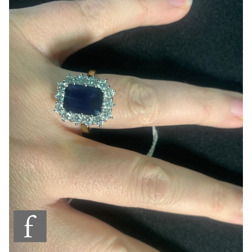 65 - An 18ct hallmarked sapphire and diamond cluster ring, emerald cut sapphire, weight 3.36ct, within a ... 