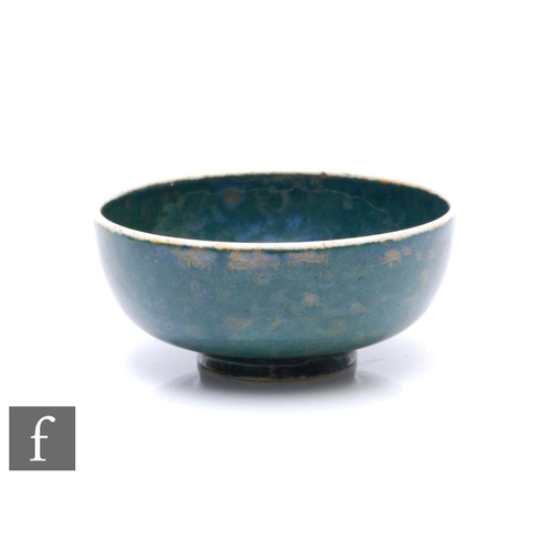 125 - Ruskin Pottery - A miniature 1930s pottery bowl of footed circular form, decorated with a tonal blue... 