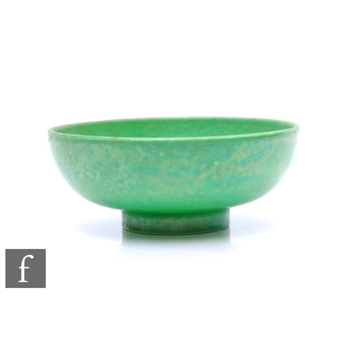 132 - Ruskin Pottery - A small pottery bowl of footed circular form, decorated in an apple green glaze wit... 