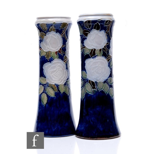 68 - Royal Doulton - A pair of stoneware vases with tubelined decoration by Ethel Beard with flowering ro... 