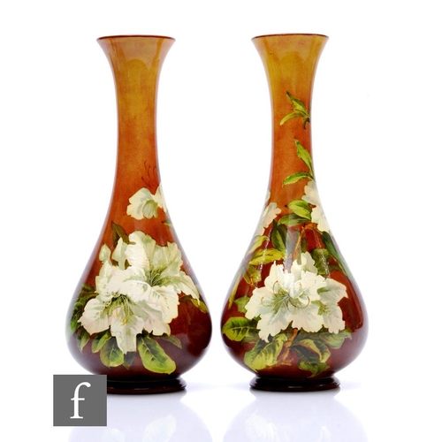 74 - Doulton Lambeth - A pair of early 20th Century Faience ware vases of footed globe and shaft form wit... 