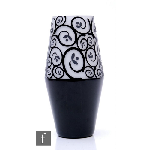 389 - A contemporary Art Glass vase of barrel form, cased in black over white and cut to reveal a scrollin... 