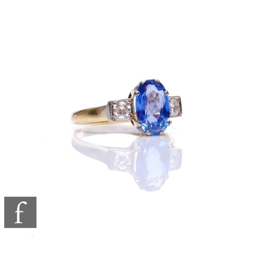 72 - An 18ct hallmarked sapphire and diamond three stone ring, central oval cornflower blue sapphire flan... 