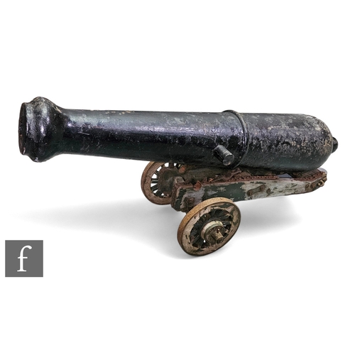 774 - A 20th Century of earlier black painted cast iron canon, length 110cm, on wooden and iron wheel carr... 