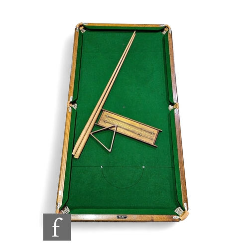 779 - A 1930s quarter or child's size table top snooker table with cue, balls, score board and accessories... 