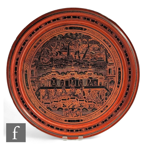 815 - A 20th Century Indian cinnabar lacquered circular serving tray decorated with figures and detailed t... 