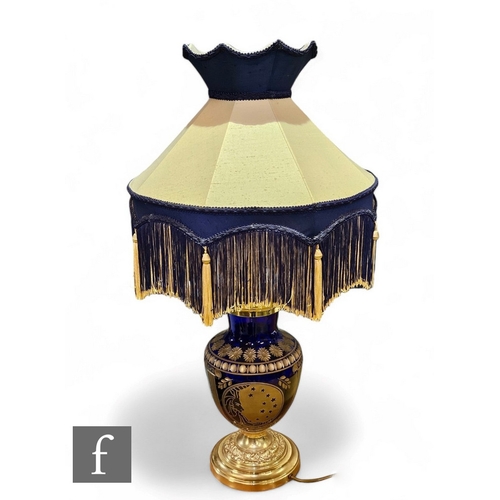 852 - A modern 20th Century blue and gilt cut glass table lamp of ovoid form decorated with panels of clas... 