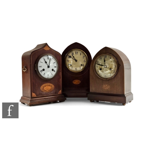 869 - An Edwardian inlaid mahogany mantle clock, eight day striking movement, and two similar lancet shape... 