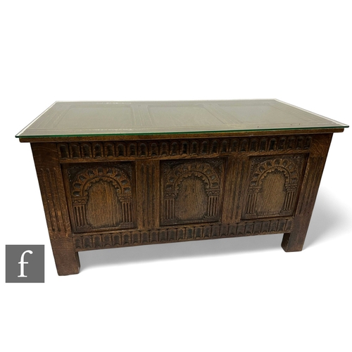 1009 - A 17th Century style carved oak triple panelled coffer, arched front enclosed by a lid, height 57cm ... 