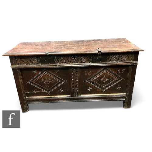 1011 - An 18th Century carved oak coffer, triple lozenge panelled front on stiles below a moulded edge top,... 