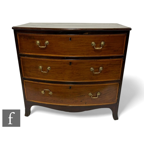 1045 - A George III mahogany bowfront chest of three satinwood crossbanded and line inlaid drawers, brass s... 