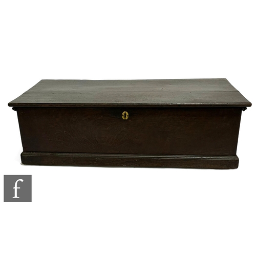 1051 - A George III oak deed box, the hinged top over a plinth base, width 85cm.