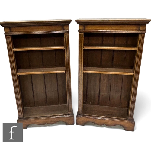 1076 - A pair of Edwardian style oak floorstanding bookcases, the adjustable shelf interior flanked by a pa... 