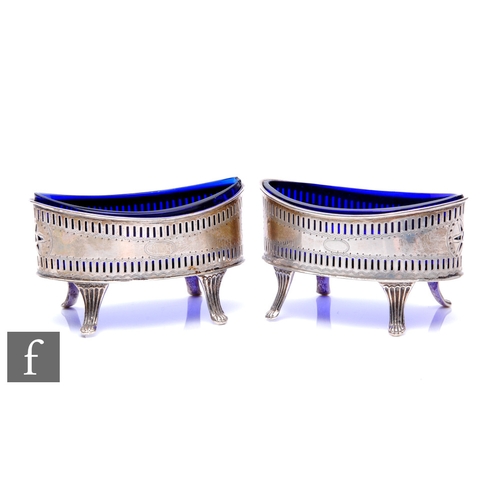 306 - A pair of Edwardian silver boat shaped salts in the Georgian style, each with a blue glass liner on ... 