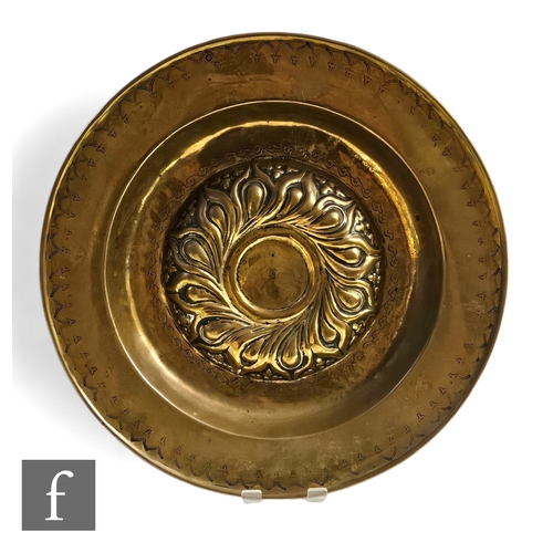 314 - A 16th or 17th Century brass alms dish with raised embossed centre, detailed flange border, width 39... 