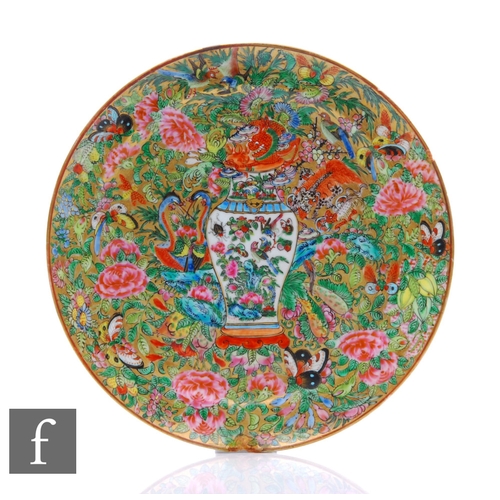 321 - A 19th Century Cantonese famille rose patterned plate, centred with a white vase and decorated with ... 